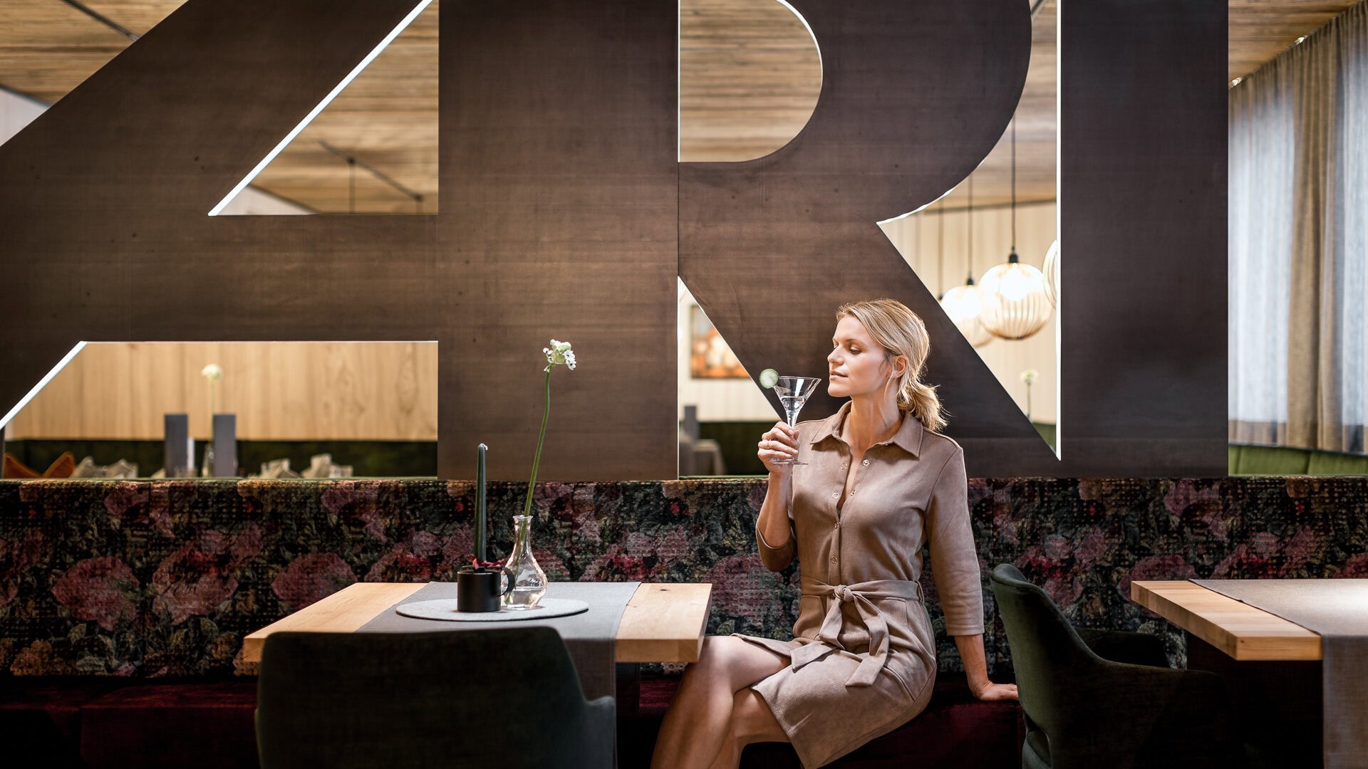 Frau trinkt im stilvollen Restaurant einen Martini.