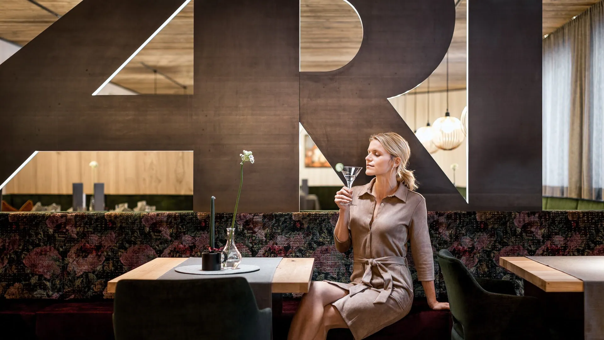 Vrouw drinkt een Martini in een stijlvol restaurant.