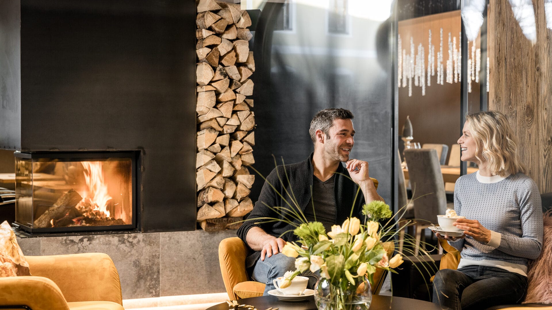 Paar genießt Kaffee vor Kamin