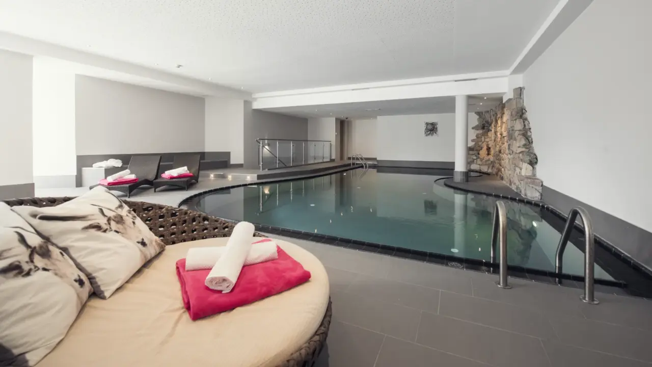 Eleganter Innenpool mit Liegestühlen und Handtüchern.
