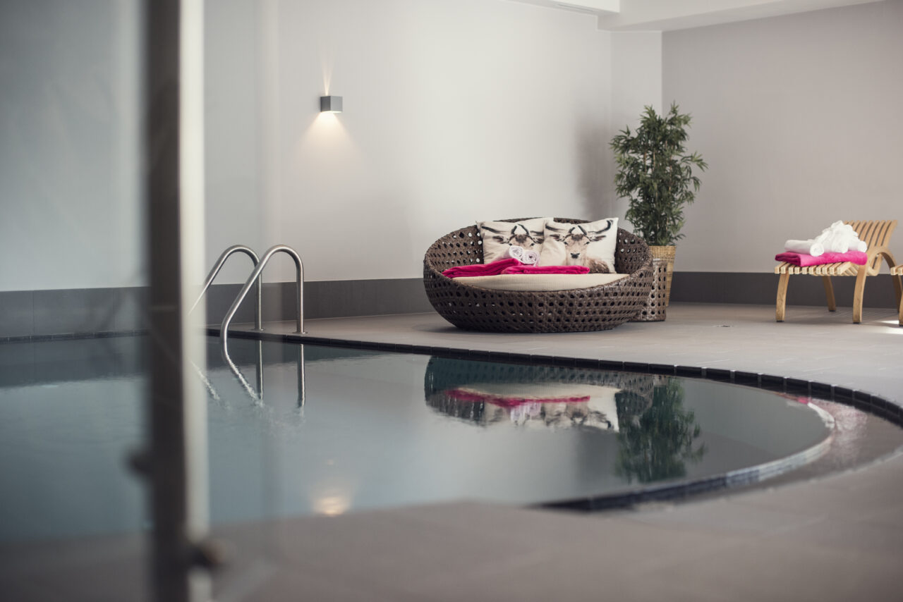 Moderner Innenpool mit gemütlicher Sitzecke
