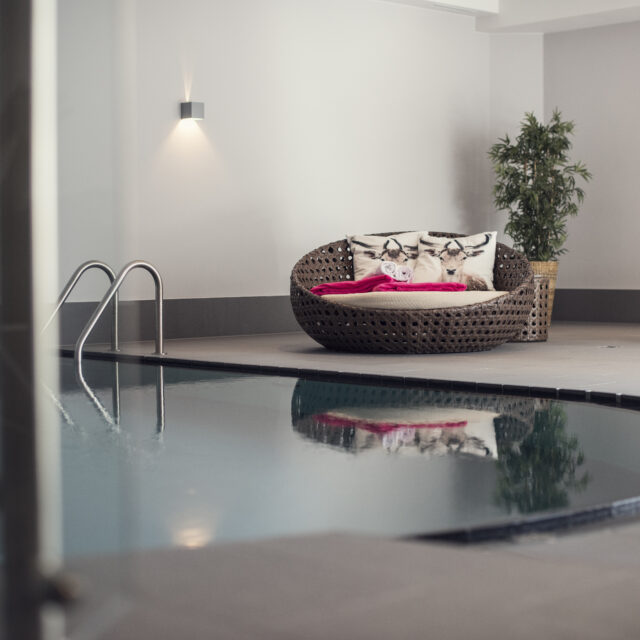 Moderner Innenpool mit gemütlicher Sitzecke