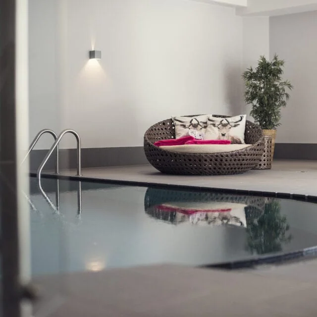 Moderner Innenpool mit gemütlicher Sitzecke