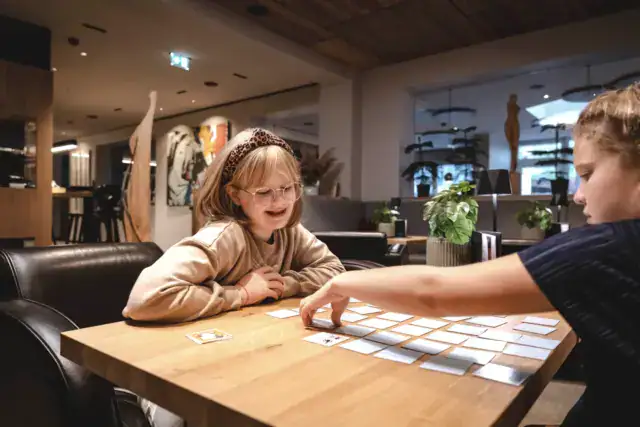 Kinder spielen Karten im Wohnzimmer