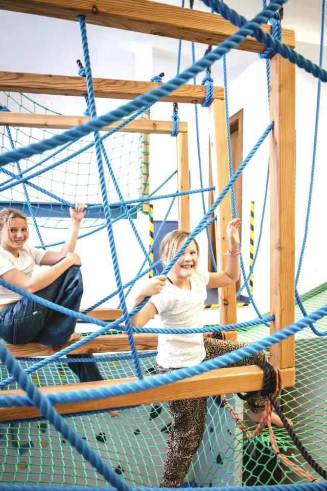 Kinder spielen in Indoor-Kletteranlage