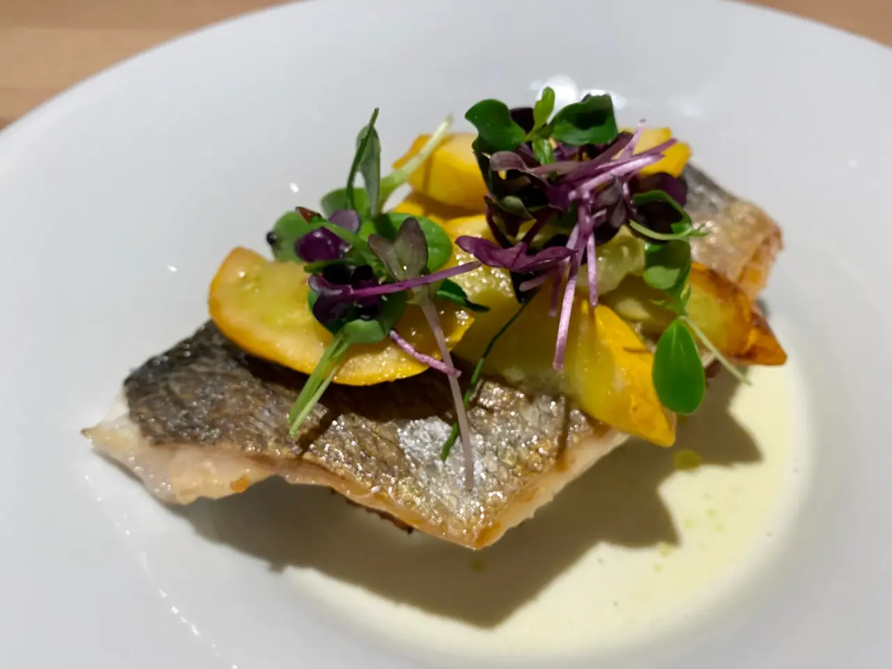 Gourmet-Fischgericht mit Gemüse auf weißem Teller