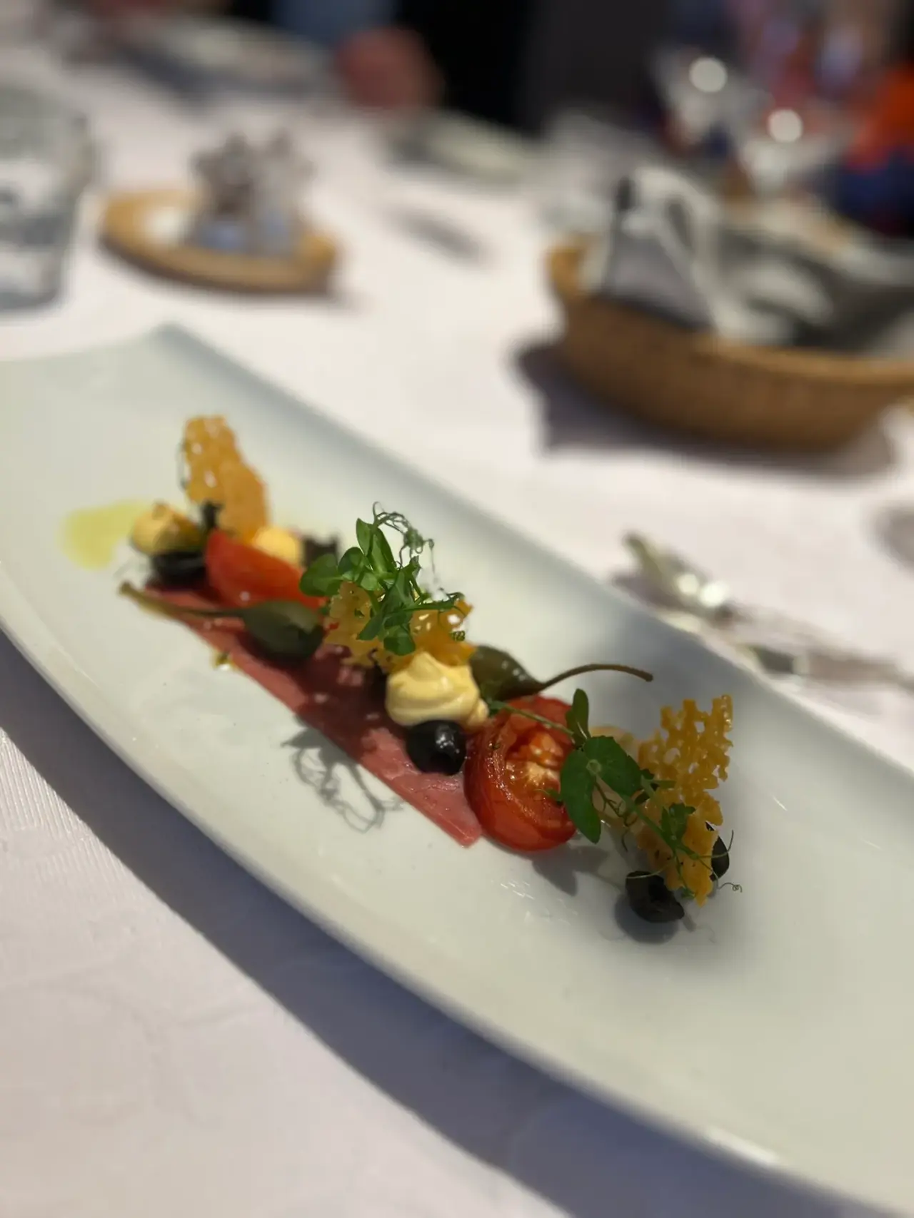 Gourmet-Vorspeise auf weißem Teller, elegant angerichtet.