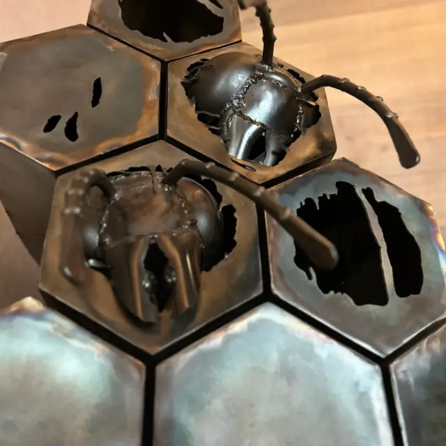 Metallkunst mit Ameisen und Wabenstruktur