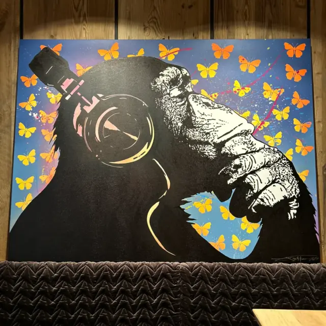 Affe mit Kopfhörern und Schmetterlingen auf Leinwand