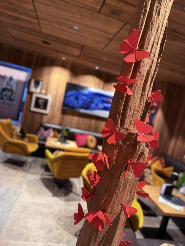 Rote Schmetterlinge auf Holzstamm in modernem Raum