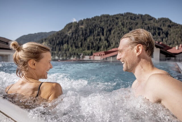Paar im Pool mit Aussicht auf Berge