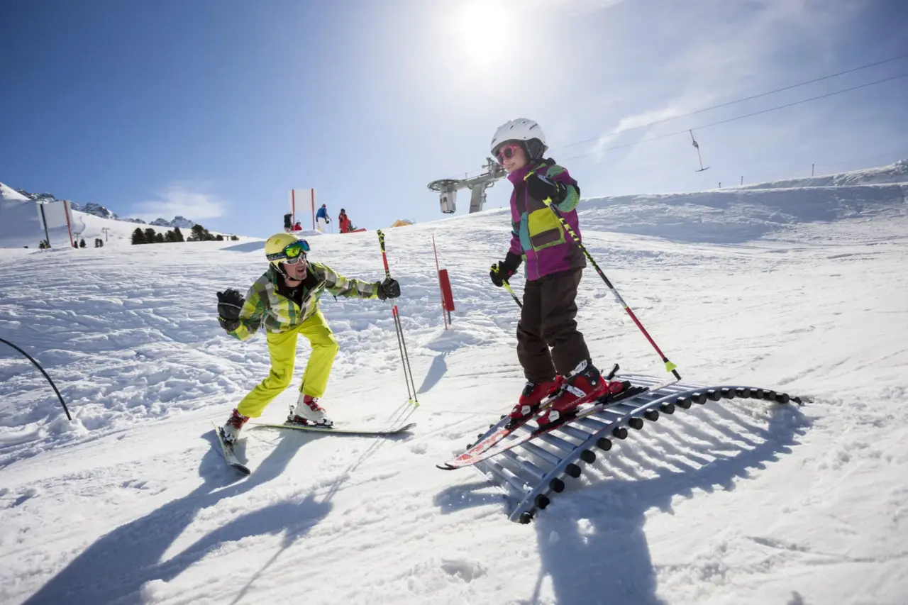 Zwei Skifahrer auf sonniger Piste.