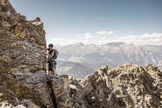Mann klettert Felsen in den Bergen.
