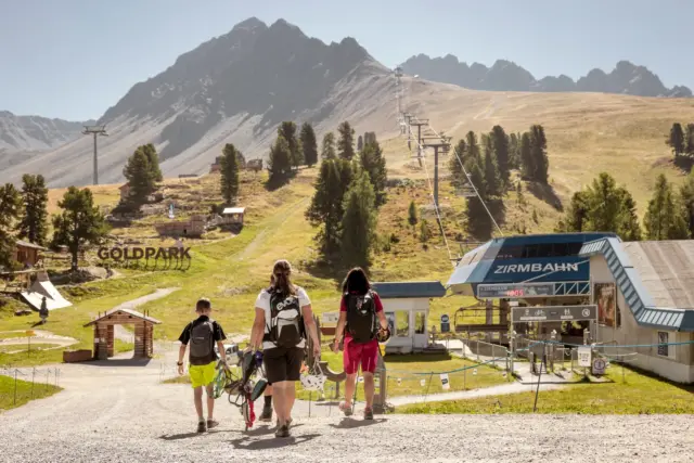 Menschen wandern bei Zirmbahn in den Bergen.