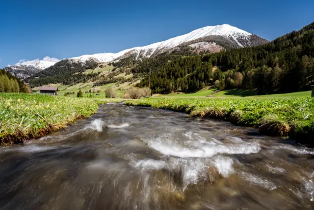 Berglandschaft mit Bach und Schnee