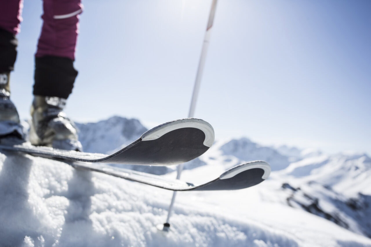 Skifahrer auf verschneitem Berg mit blauem Himmel