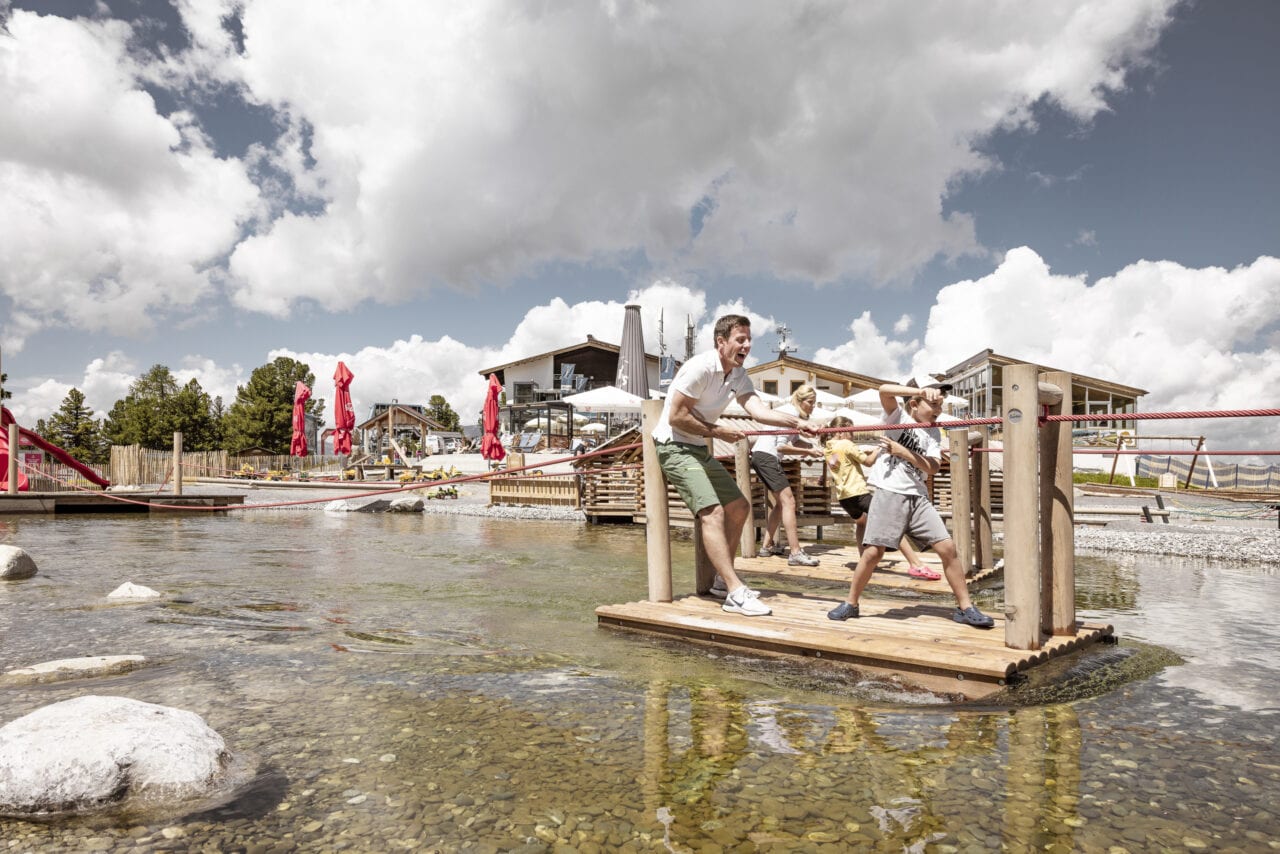 Familie spielt an einem See im Freien
