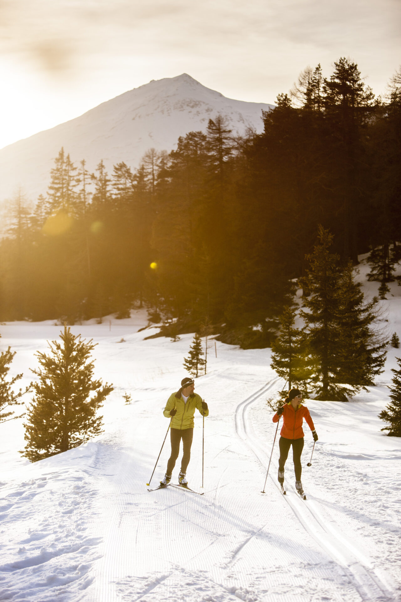 Langläufer im Winterwald bei Sonnenuntergang
