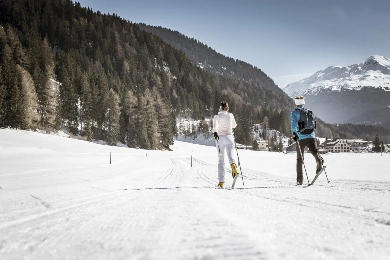 Zwei Personen beim Skilanglauf auf Schneepiste