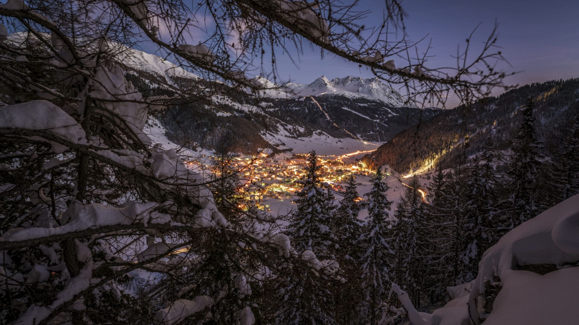 Verschneites Dorf bei Nacht in den Bergen