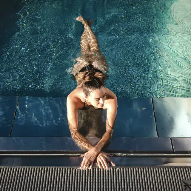 Person entspannt im Pool