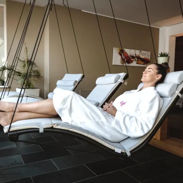 Frau entspannt in Hängeliege im Wellnessbereich