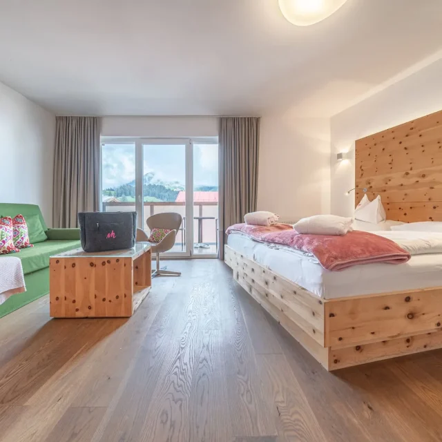 Modernes Hotelzimmer mit Holzmöbeln und Bergblick.