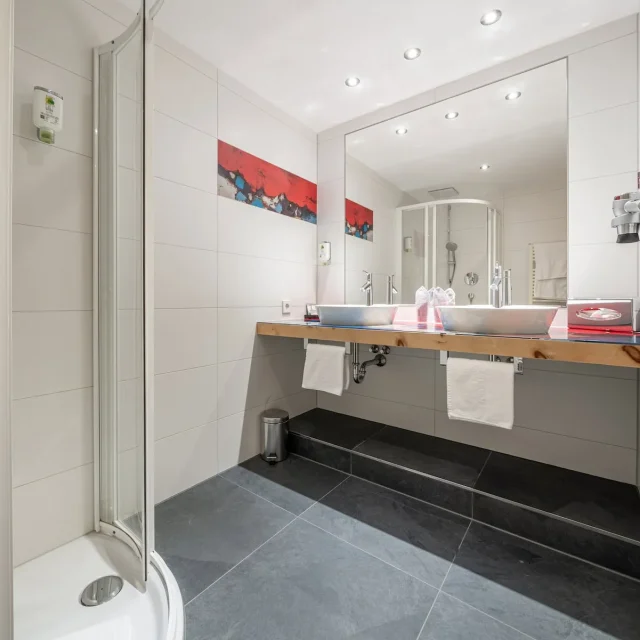 Modernes Badezimmer mit Dusche und großem Spiegel