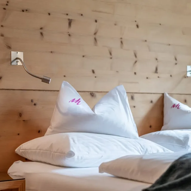 Doppelbett mit Holzrückwand und Kissen