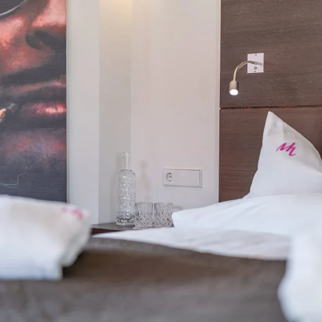 Hotelzimmer mit Bett und Kunstwerk an der Wand.