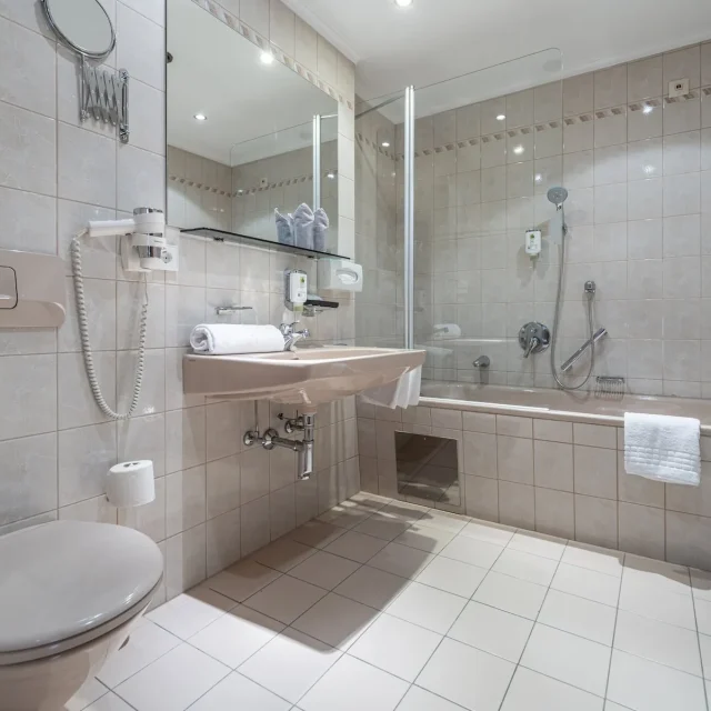 Sauberes Badezimmer mit Dusche und Badewanne, inklusive Haartrockner und Handtücher, im Naudererhof.