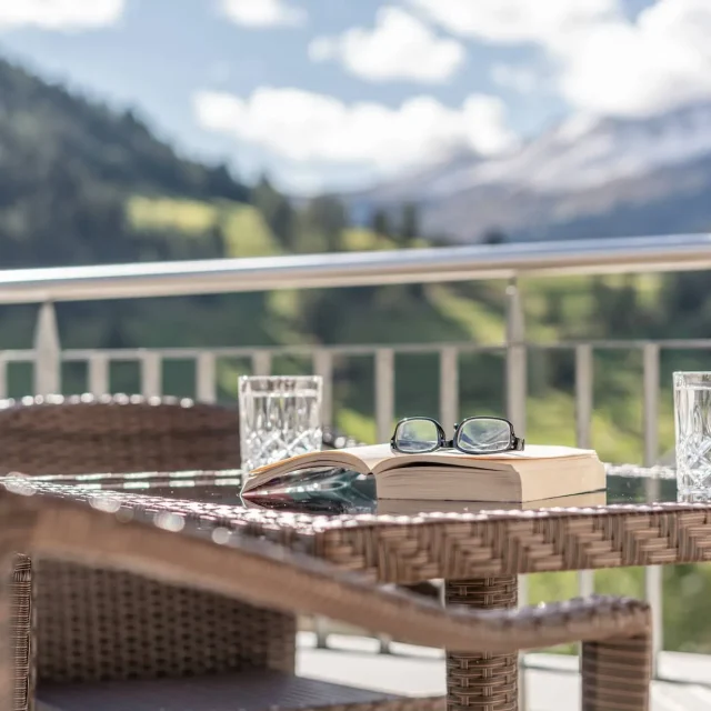 Terrasse mit Buch, Brille und Wassergläsern