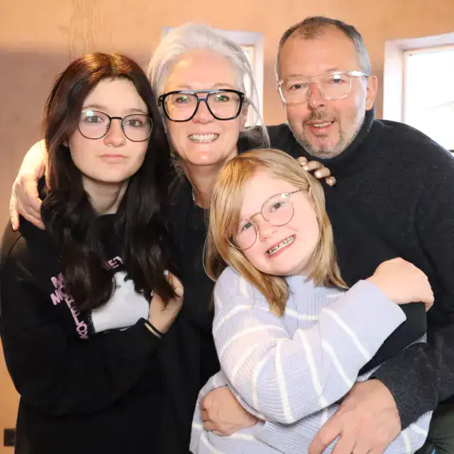 Vier fröhliche Personen posieren zusammen.