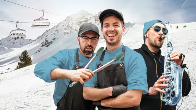 Drei Männer im Schnee mit Musikinstrument.